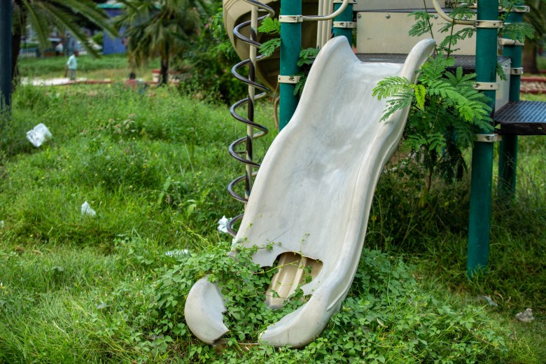 The plastic slide at the Petion Square playground in Champs-de-Mars, taken on November 17, 2022. The plastic rots in the space, often overrun by used paper plates, cardboard and overgrown weeds fill the space. Photo by Marvens Compère for The Haitian Times