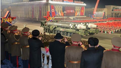 North Korean intercontinental ballistic missiles move past leader Kim Jong Un in a reviewing stand during Wednesday night's military parade in Pyongyang.