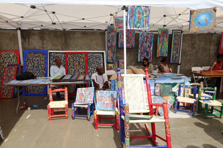Straw chairs and paintings on display during the first edition of Gwoup Eritaj’s Agricultural and Artisanal Resistance Fair in Pétion-Ville, Port-au-Prince, on May 1, 2025. Photo by Dieugo André for The Haitian Times.