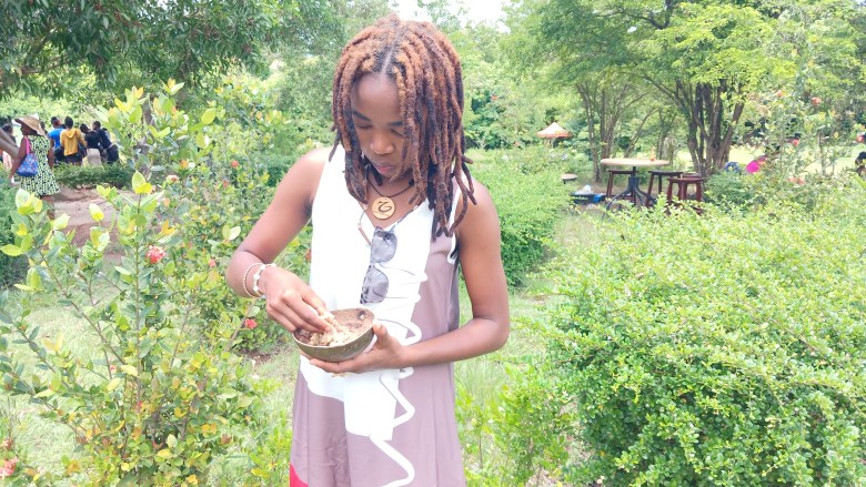 A local tourist enjoys a bowl of mousa at a food fair in the Ouanaminthe botanical garden on May 1, 2025. Photo by Edxon Francisque / The Haitian Times..