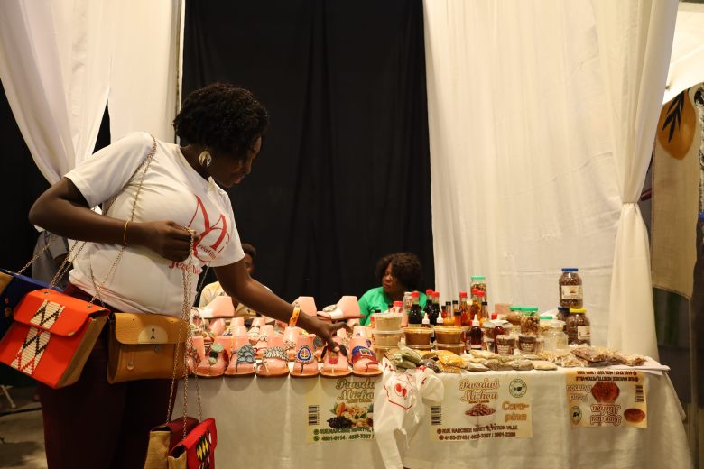 Handmade suitcases, sandals and local products—beans, peanuts and honey syrup—on display during Gwoup Eritaj’s Agricultural and Artisanal Resistance Fair in Pétion-Ville, Port-au-Prince, on May 1, 2025. Photo by Dieugo André for The Haitian Times.