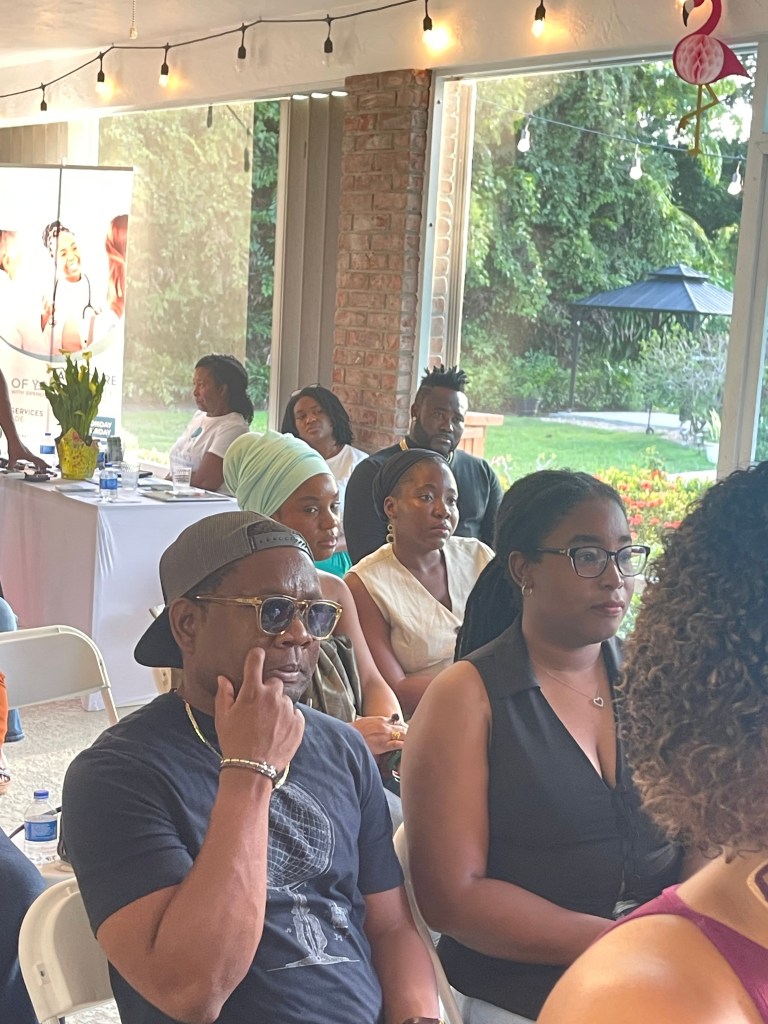 Attendees of the book signing event at Lotus Mansion in Coral Springs, Florida, including some men, attentively listen to the feminists speaking on July 27, 2025. Photo by Fritznel D. Octave/The Haitian Times.