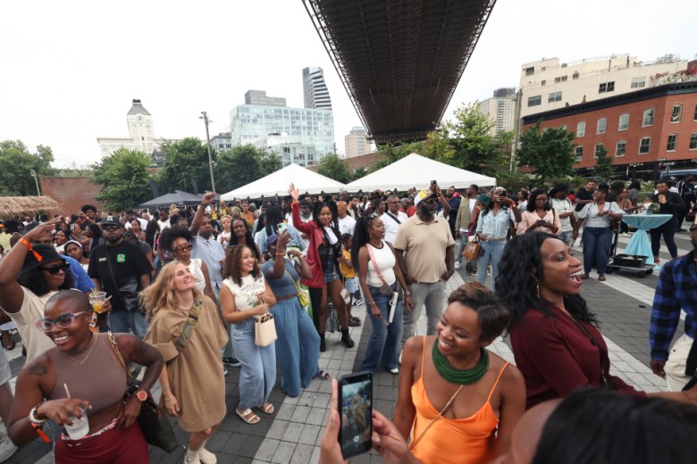 Guests dance beneath the Brooklyn Bridge during the Creole Food Festival in Brooklyn on Saturday, Sept. 27, 2025. The annual multicultural event celebrates the African Creole diaspora at Emily Roebling Plaza under the Brooklyn Bridge. Photo by Bill Farrington.
