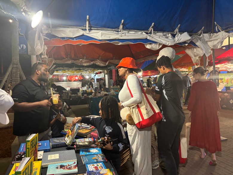 Fairgoers browse the book selection at the Miami Book Fair block party on Sunday, Nov. 16. Photo by Béatrice Vallières for the Haitian Times