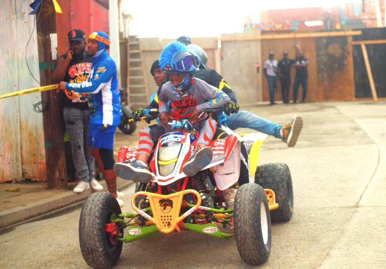 Four people ride together on a four-wheeler as part of a stunt during the third edition of the Ruff Ryders Block Party on March 7, 2026, in Cap-Haïtien. Photo by Onz Chéry / The Haitian Times.
