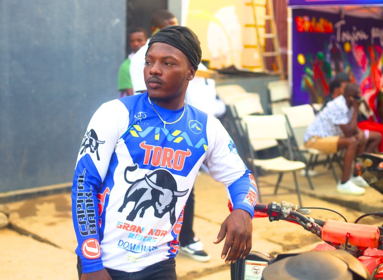A rider stands next to his motorcycle on Street 24A in Cap-Haïtien before the start of the Ruff Ryders Block Party on March 7, 2026. Photo by Onz Chéry / The Haitian Times.
