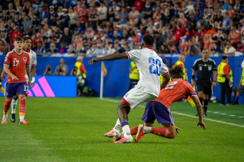 Frantzdy Pierrot of Les Grenadiers challenges Aaron Hickey a Scotland defender for possession during Haiti’s Group C match at the 2026 FIFA World Cup at Gillette Stadium in Foxborough, Massachusetts, on June 13, 2026. Photo by Fredner Cayemitte / The Haitian Times.