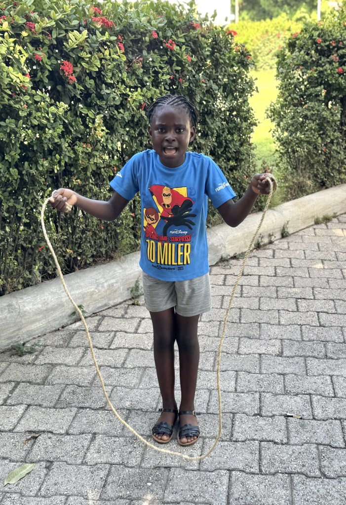 A young girl jumps rope during “Let’s Play Together” on Saturday, Aug. 15, 2026, at Lycée Anacaona in Léogâne, Haiti. Photo by Daniella Saint-Louis for The Haitian Times.